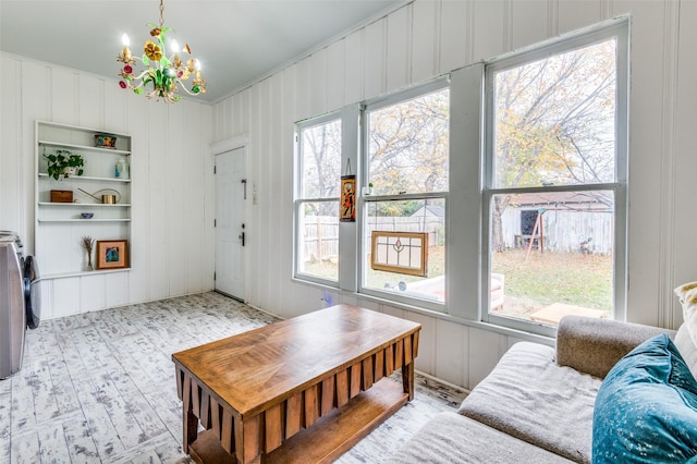 living room featuring a chandelier, light hardwood / wood-style floors, and built in features