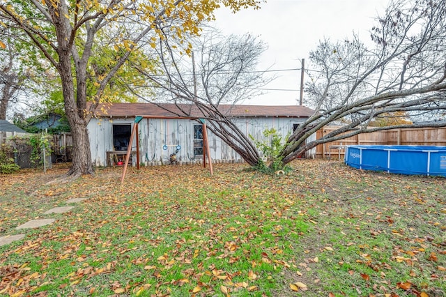 rear view of house with a fenced in pool