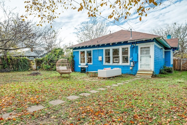 rear view of property featuring a lawn