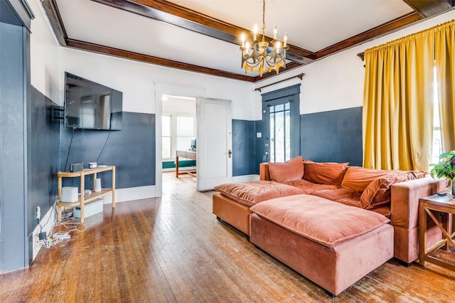 living room with hardwood / wood-style flooring, crown molding, beamed ceiling, and an inviting chandelier