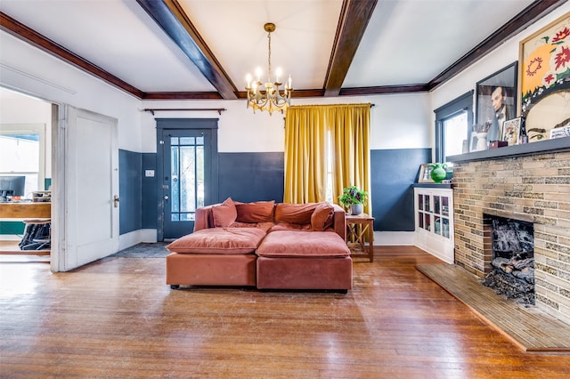 living room with a fireplace, hardwood / wood-style flooring, plenty of natural light, and a notable chandelier