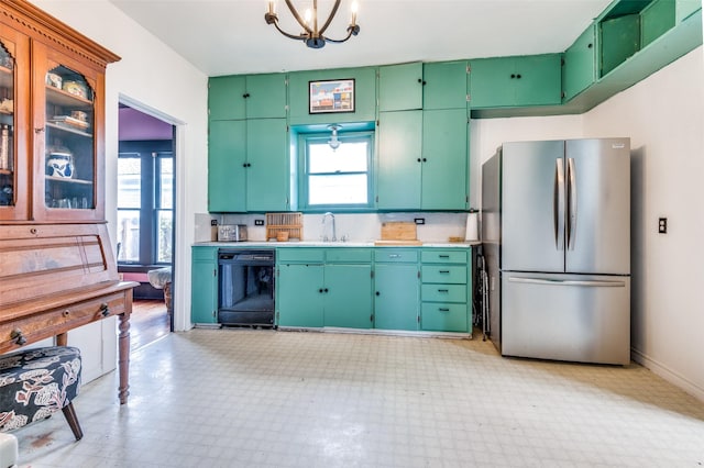 kitchen featuring a notable chandelier, black dishwasher, sink, and stainless steel fridge