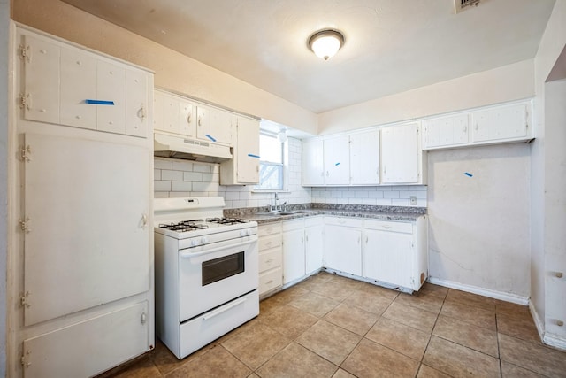 kitchen featuring tasteful backsplash, gas range gas stove, sink, white cabinets, and light tile patterned flooring