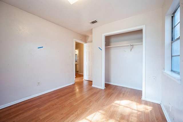 unfurnished bedroom with light wood-type flooring and a closet