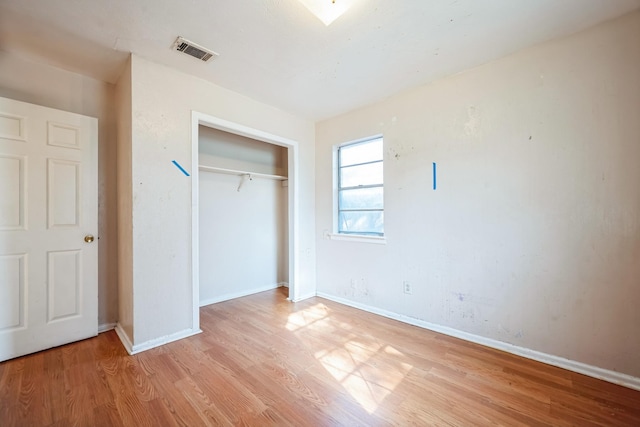 unfurnished bedroom featuring light hardwood / wood-style flooring and a closet