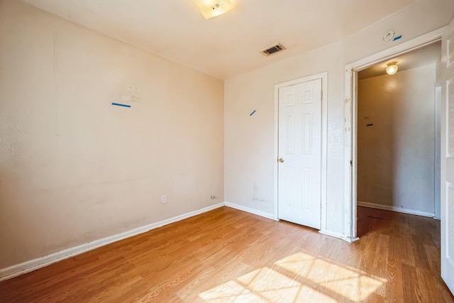 unfurnished bedroom with light wood-type flooring and a closet