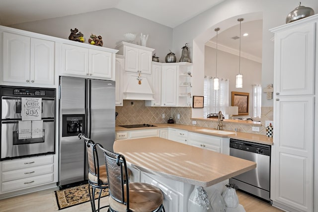 kitchen with pendant lighting, backsplash, sink, white cabinetry, and stainless steel appliances