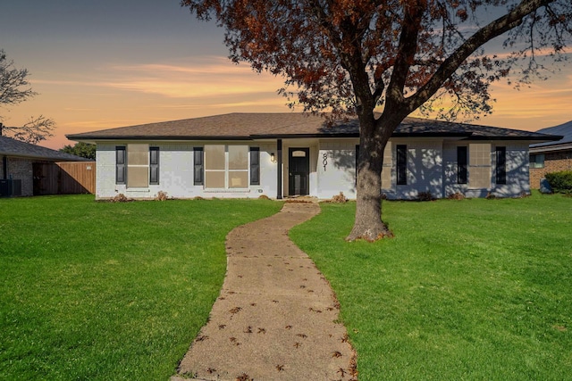 single story home with a yard, cooling unit, and fence