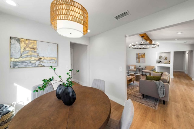 dining area featuring lofted ceiling with beams, a chandelier, recessed lighting, visible vents, and light wood finished floors