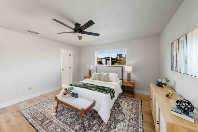 bedroom with light wood-type flooring, baseboards, visible vents, and ceiling fan