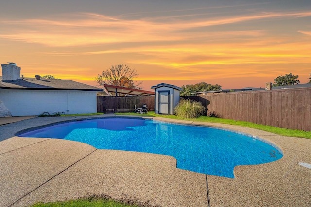 view of pool with an outbuilding, a shed, a fenced backyard, and a fenced in pool