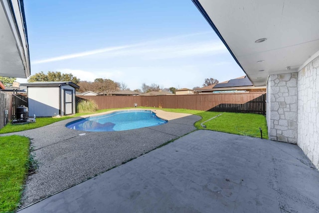 view of swimming pool with a storage shed, a fenced backyard, a patio area, and an outdoor structure