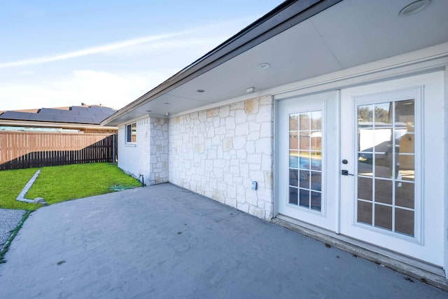 view of patio featuring french doors and fence