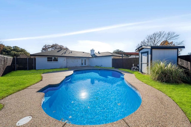 view of pool featuring a yard, a fenced backyard, a fenced in pool, and an outdoor structure