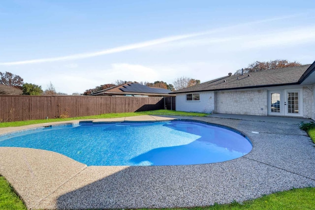 view of swimming pool with a fenced backyard, a fenced in pool, and french doors