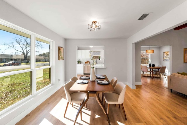 dining area featuring light wood-type flooring, visible vents, and a healthy amount of sunlight