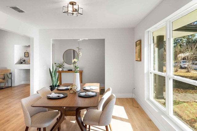 dining room with a wealth of natural light, light wood-type flooring, and visible vents