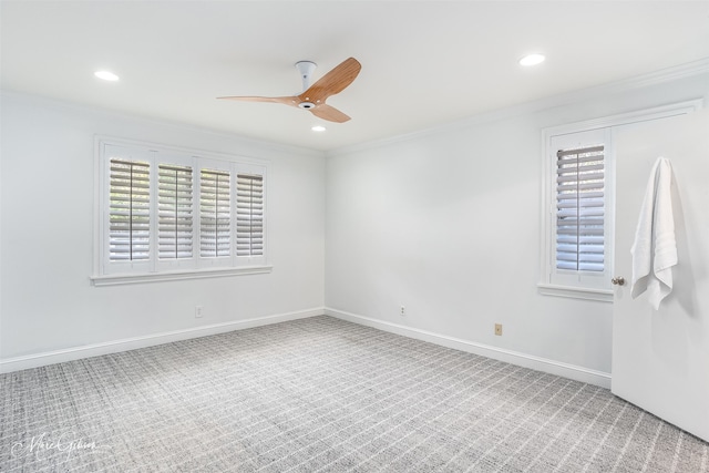 carpeted spare room with ceiling fan and ornamental molding