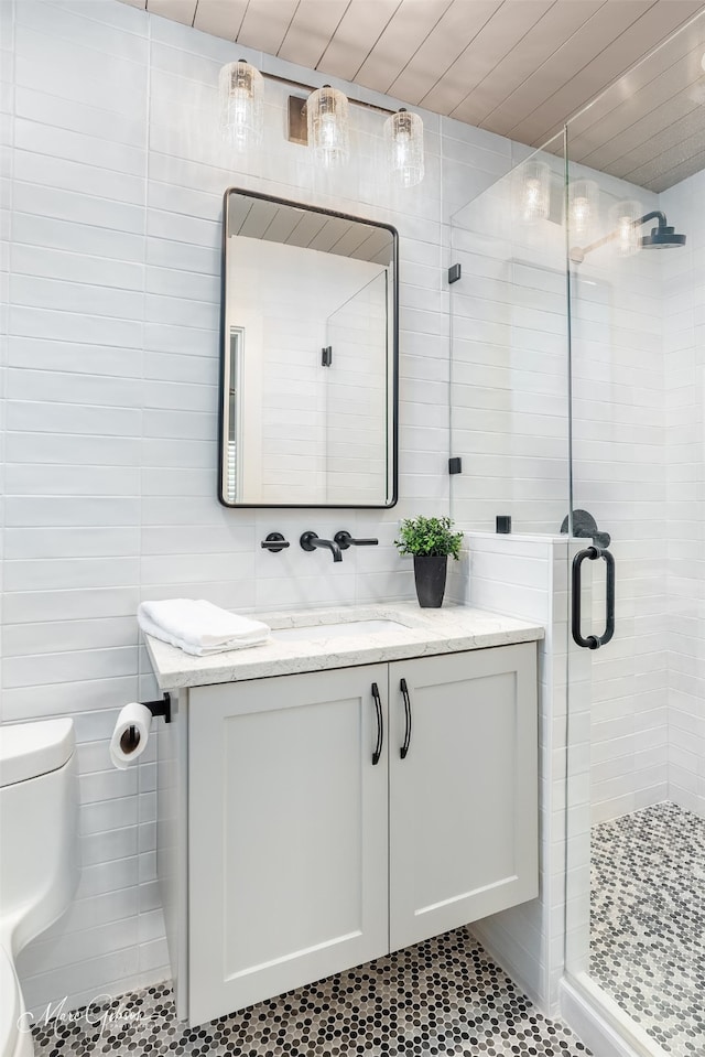 bathroom featuring tile patterned flooring, vanity, toilet, and a shower with shower door