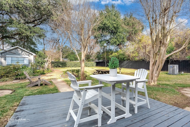 wooden terrace featuring a yard and cooling unit