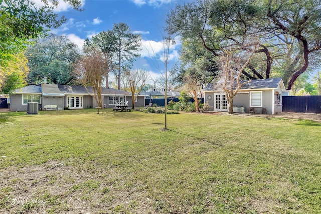 view of yard with central AC and french doors