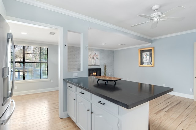 kitchen featuring white cabinetry, stainless steel fridge, light hardwood / wood-style floors, and kitchen peninsula