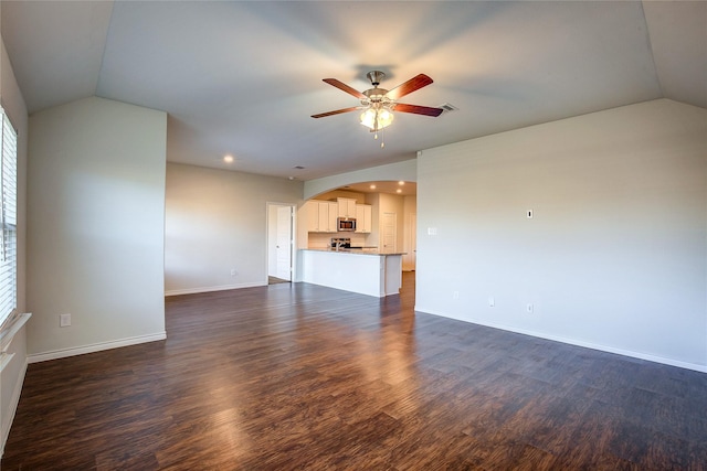 unfurnished living room with vaulted ceiling, dark hardwood / wood-style floors, and ceiling fan