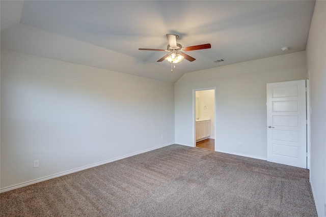 unfurnished bedroom with carpet, ceiling fan, ensuite bathroom, and vaulted ceiling