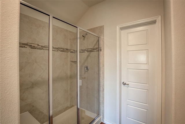 bathroom with vaulted ceiling and an enclosed shower