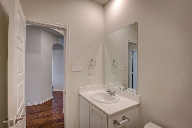 bathroom featuring vanity, wood-type flooring, and toilet