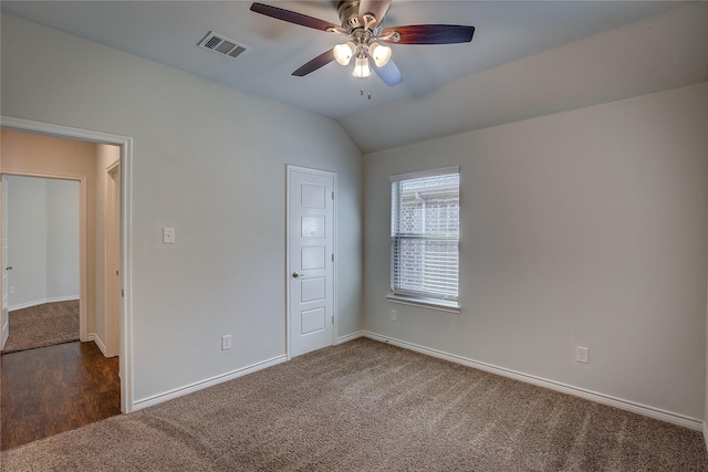 unfurnished bedroom featuring ceiling fan, dark carpet, and vaulted ceiling