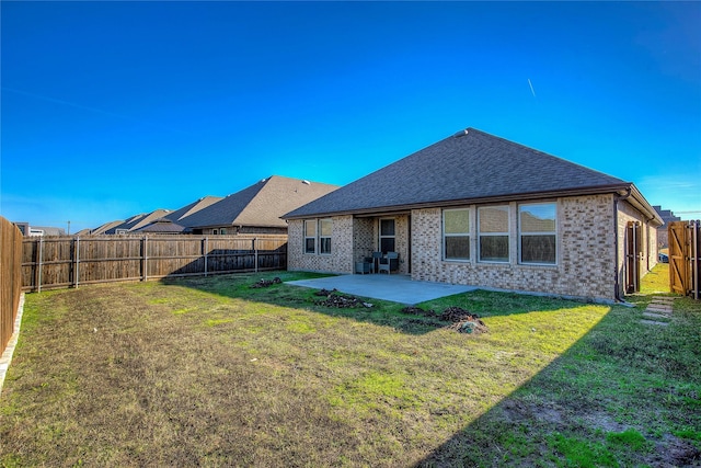 back of property with a yard and a patio