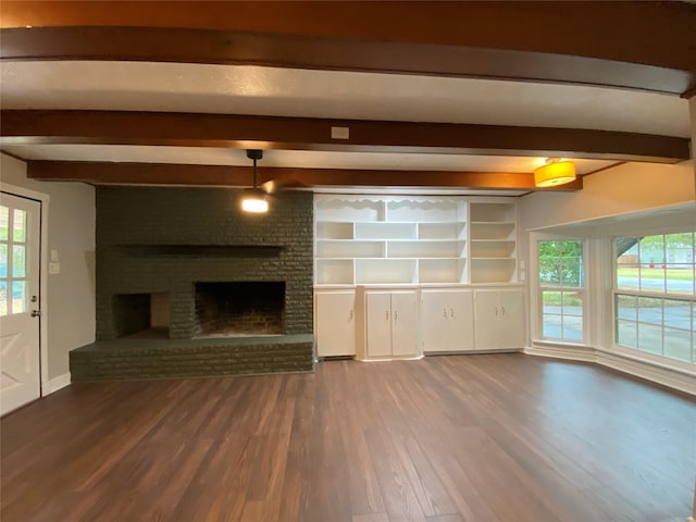 unfurnished living room with beamed ceiling, wood-type flooring, built in features, and a fireplace