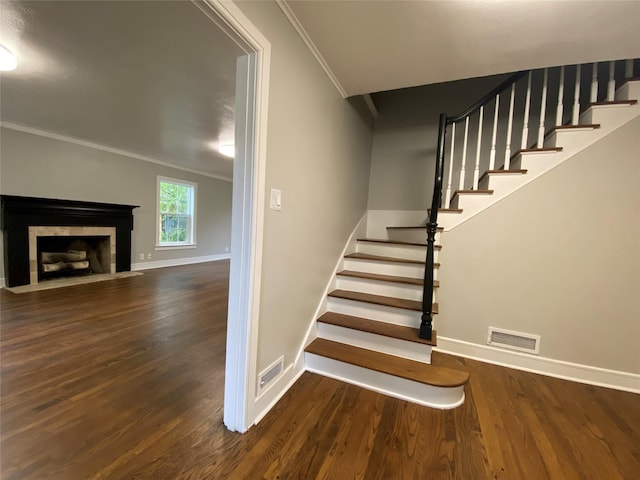 stairway featuring wood-type flooring and ornamental molding