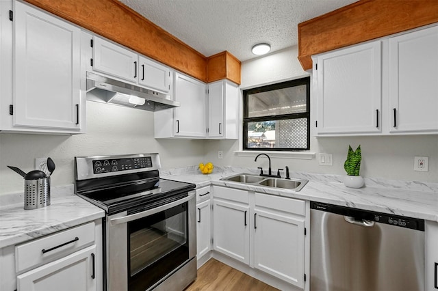 kitchen featuring white cabinetry, sink, light hardwood / wood-style flooring, a textured ceiling, and appliances with stainless steel finishes