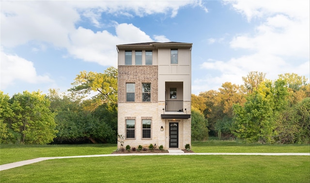 contemporary house with a front yard and a balcony