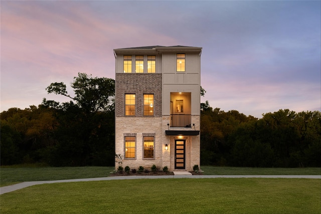 contemporary house with a balcony and a yard