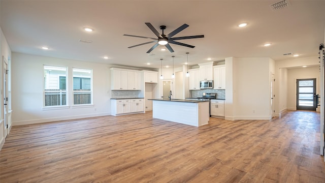 kitchen with white cabinets, an island with sink, and appliances with stainless steel finishes