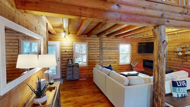 living room featuring beam ceiling, dark hardwood / wood-style flooring, wood ceiling, and rustic walls