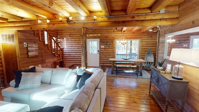 living room featuring beam ceiling, log walls, a notable chandelier, wood ceiling, and hardwood / wood-style flooring