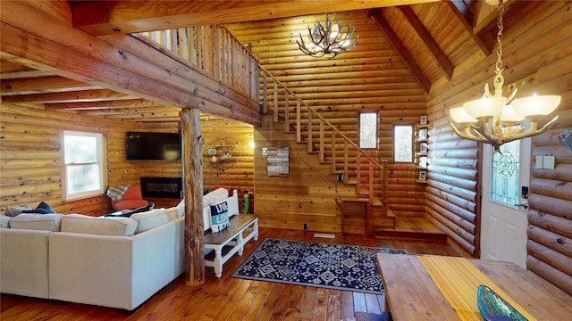 living room featuring beamed ceiling, high vaulted ceiling, an inviting chandelier, and log walls