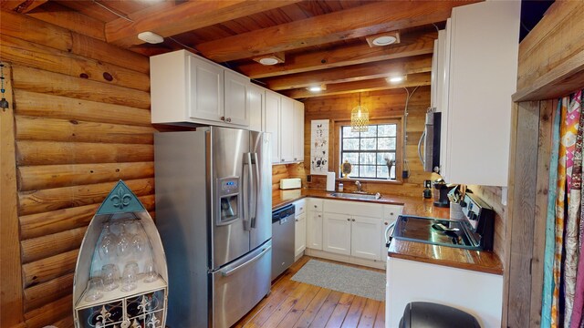 kitchen featuring white cabinetry, beamed ceiling, hanging light fixtures, and appliances with stainless steel finishes