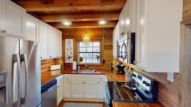 kitchen featuring white cabinets, sink, beamed ceiling, decorative light fixtures, and stainless steel appliances