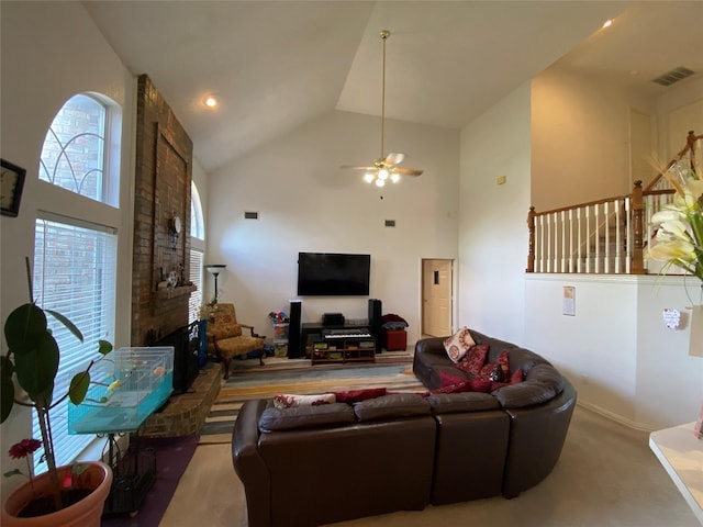 living room featuring carpet flooring, ceiling fan, a fireplace, and high vaulted ceiling