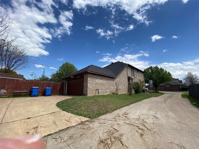 view of side of property featuring a garage and a yard