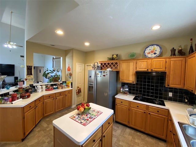 kitchen featuring hanging light fixtures, black gas cooktop, stainless steel refrigerator with ice dispenser, backsplash, and a kitchen island