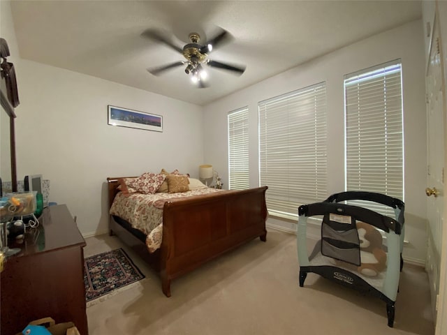 bedroom with ceiling fan and light carpet