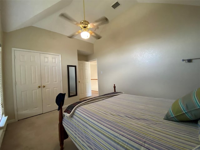 bedroom featuring light colored carpet, vaulted ceiling, a closet, and ceiling fan