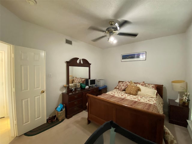 bedroom with light carpet, a textured ceiling, and ceiling fan