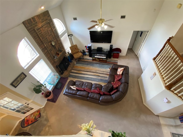 living room with carpet flooring, ceiling fan, and a towering ceiling